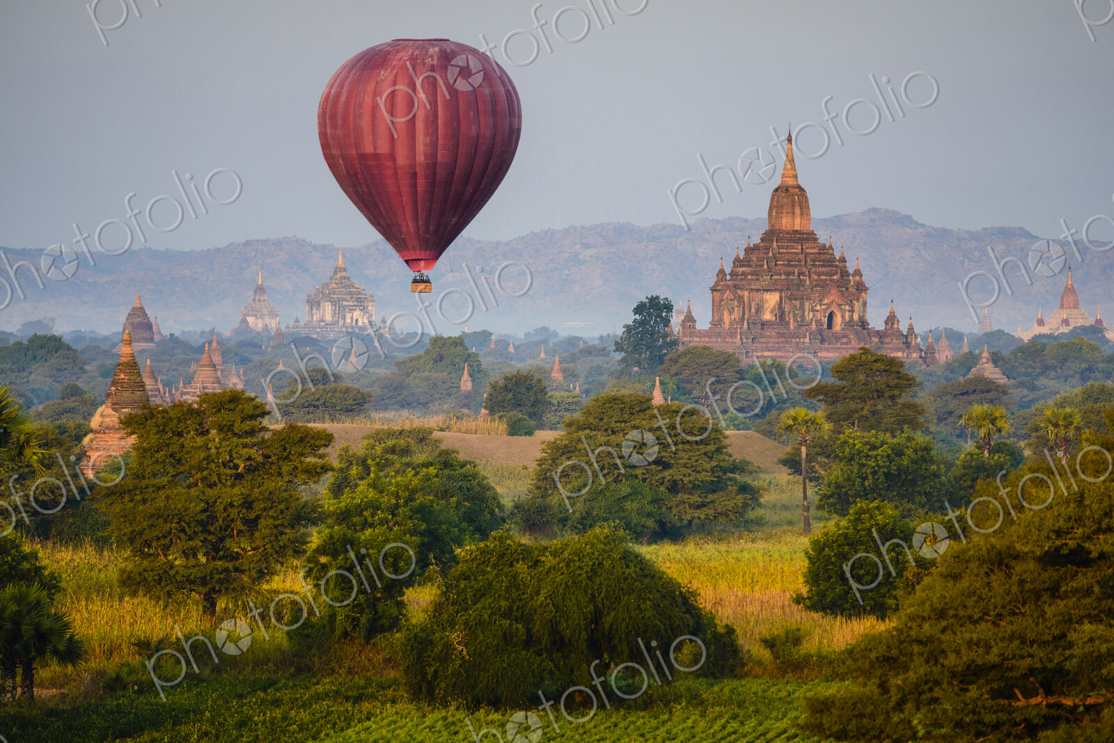 Hot air balloon flying over towers