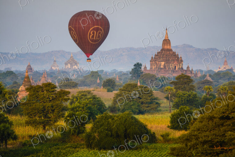 Hot air balloon in the air above a temple in Mandalay.