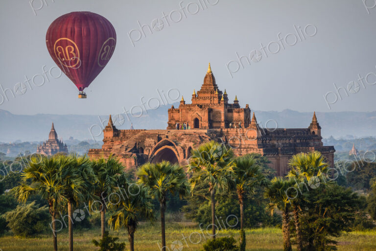 Hot air balloon in the air above a temple in Mandalay.