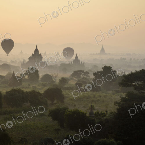 Hot air balloons flying over towers