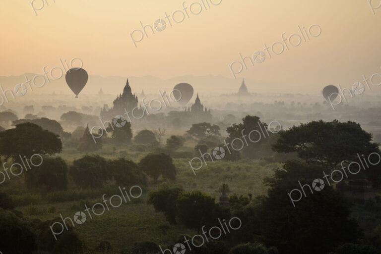 Hot air balloons flying over towers