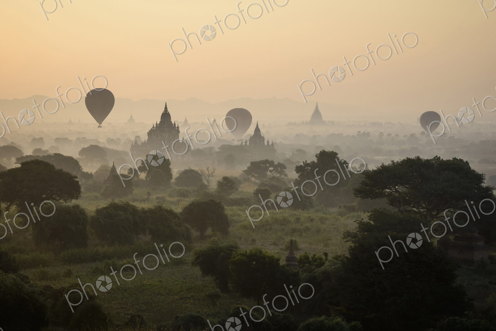 Hot air balloons flying over towers