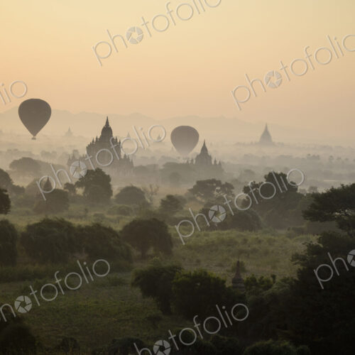 Hot air balloons hovering in the air above the plain of temples in Mandalay Hot air balloons hovering in the air above the plain of temples in Mandalay