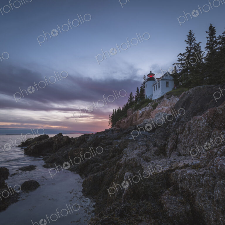 House on cliff near ocean at sunset