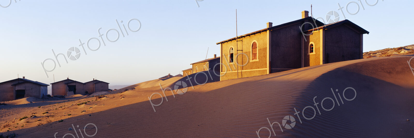 Houses buried in sand in deserted village.