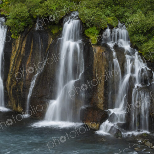 Hraunfossar waterfalls, torrents flowing from lava fields over a sheer cliff