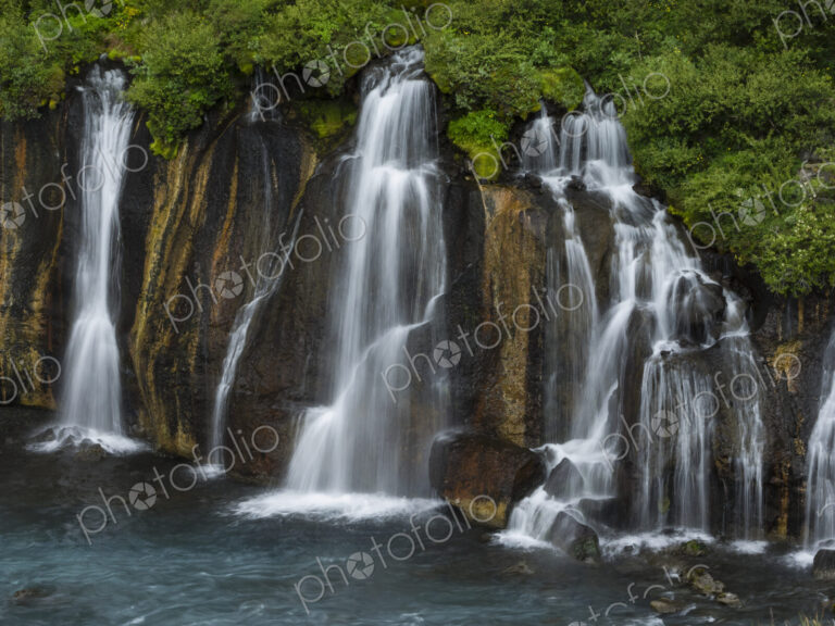 Hraunfossar waterfalls, torrents flowing from lava fields over a sheer cliff