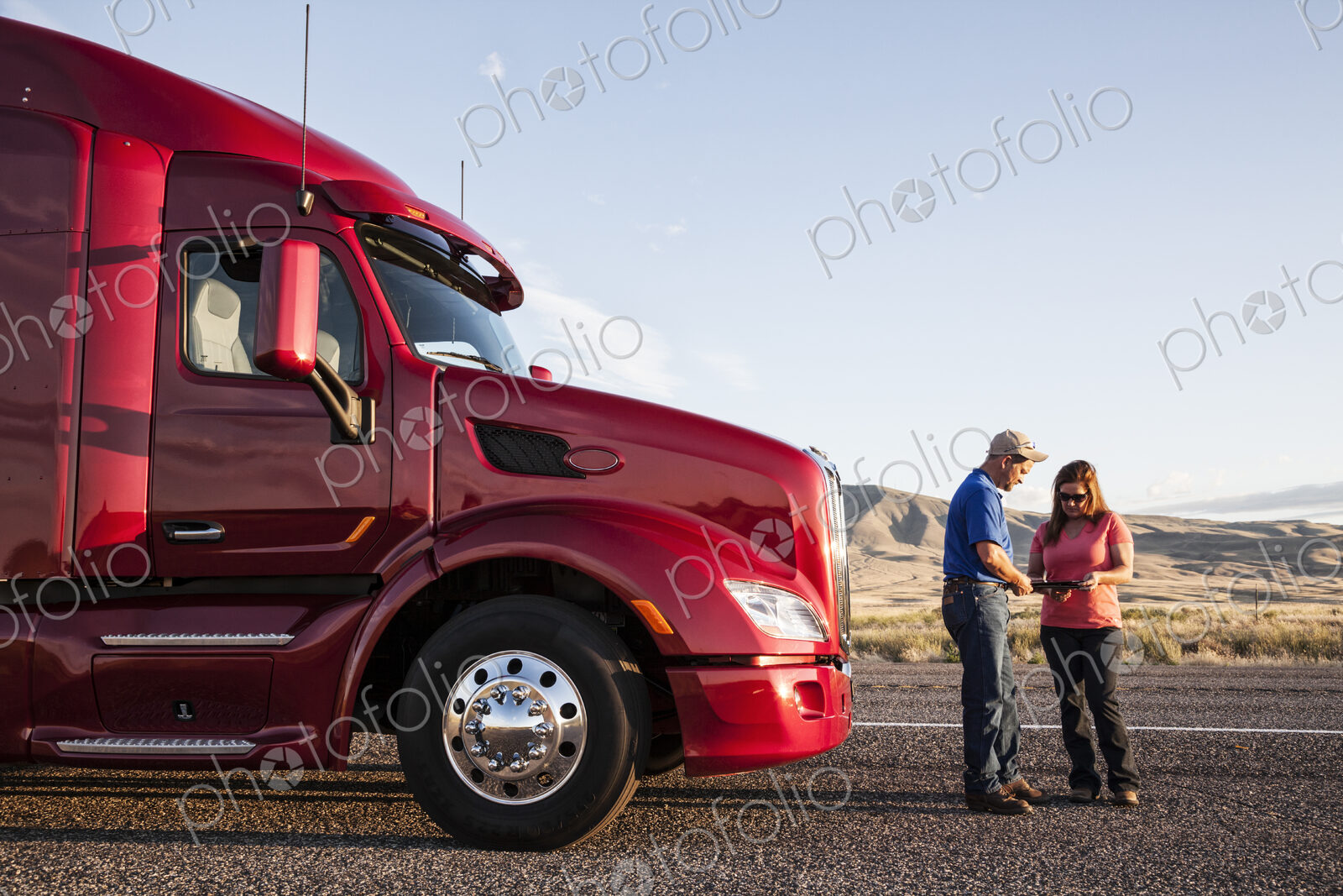 Husband and wife driving team checking their itinerary while standing in front of…