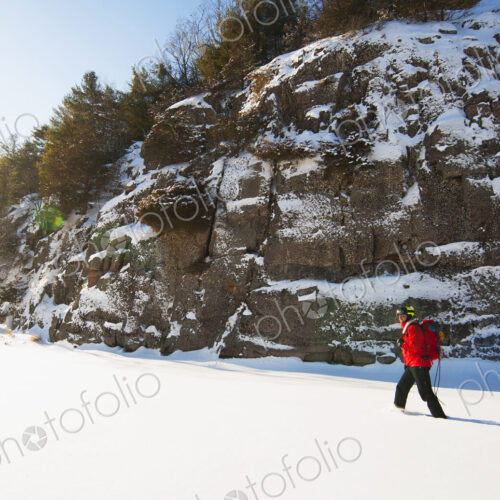 Ice climber walking in snowy field