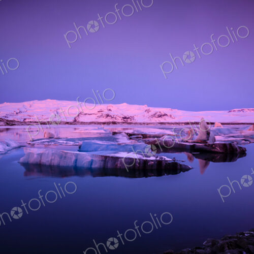 Ice floes in Iceland in pink light at dusk.