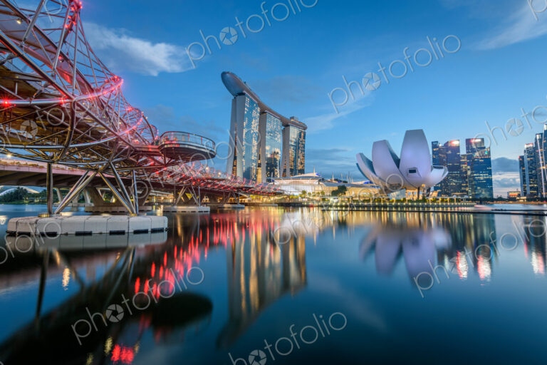 Illuminated Singapore waterfront in the evening, with Marina Bay Sands Hotel and…