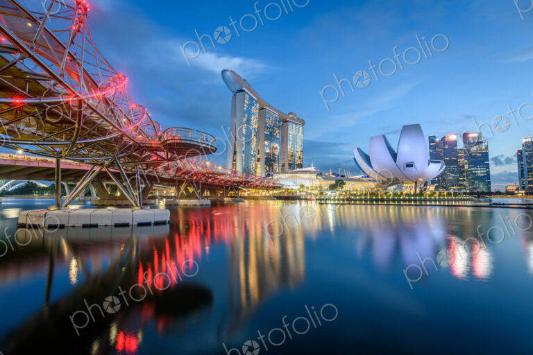 Illuminated Singapore waterfront in the evening, with Marina Bay Sands Hotel and…