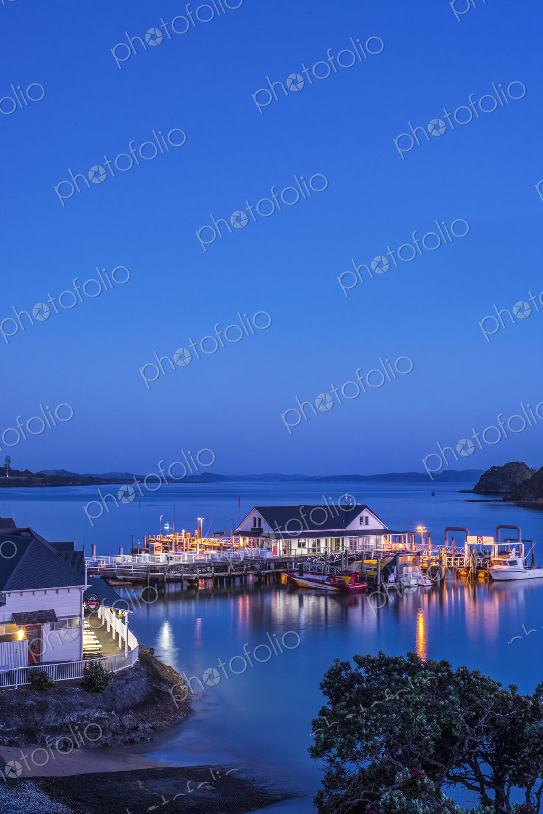 Illuminated building on water at dawn