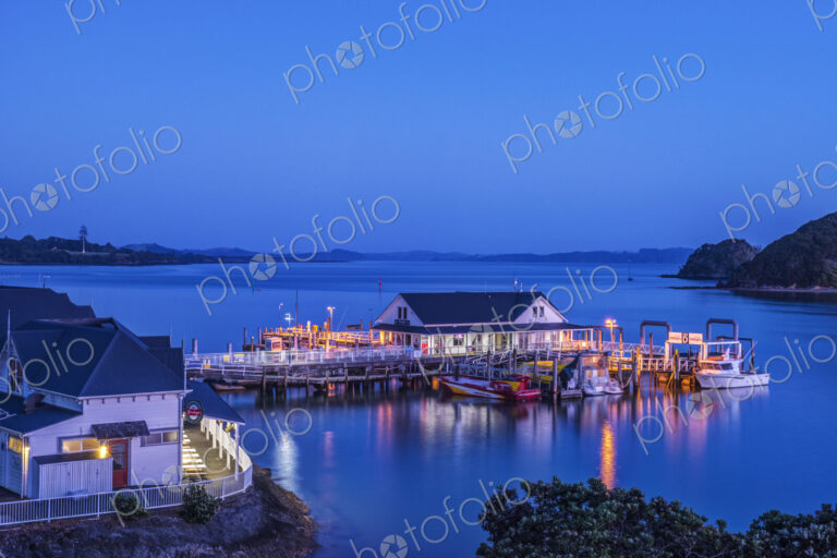 Illuminated building on water at dawn
