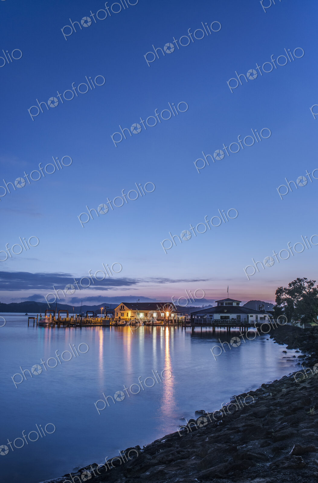Illuminated buildings on water at dawn