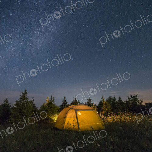 Illuminated camping tent under starry sky