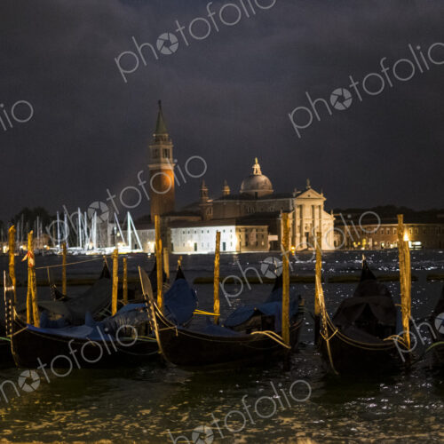 Illuminated gondolas moored in the Canale Grande in Venice, Veneto, Italy, at night…