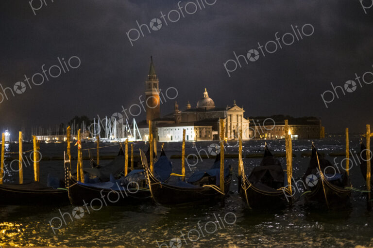 Illuminated gondolas moored in the Canale Grande in Venice, Veneto, Italy, at night…