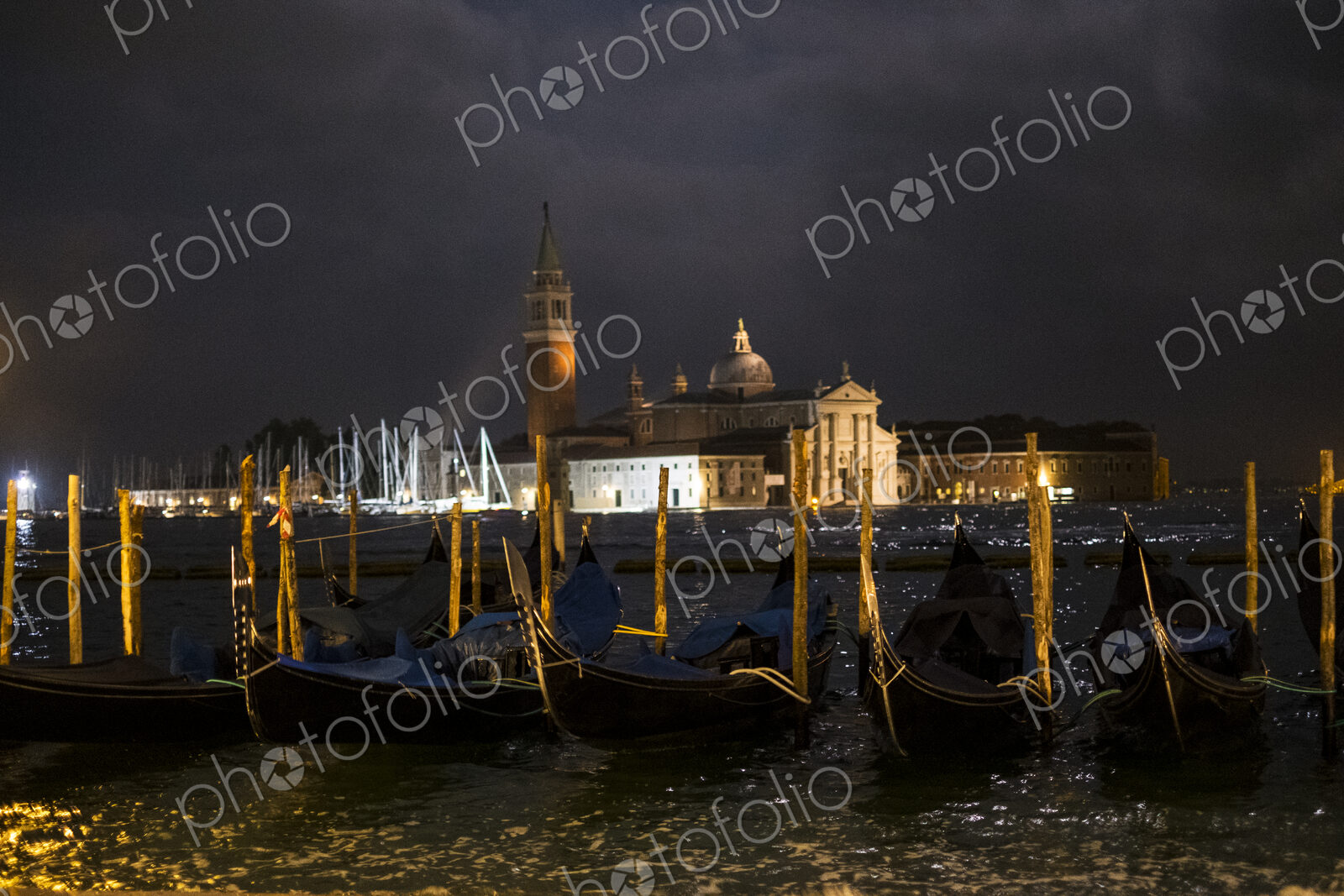 Illuminated gondolas moored in the Canale Grande in Venice, Veneto, Italy, at night…