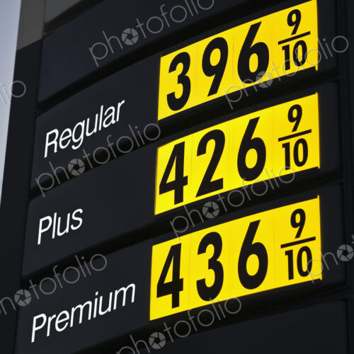 Illuminated sign, gas fuel prices at a filling station at dusk. Illuminated sign, gas fuel prices at a filling station at dusk.