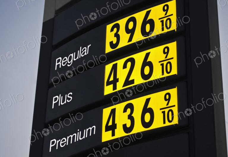 Illuminated sign, gas fuel prices at a filling station at dusk.