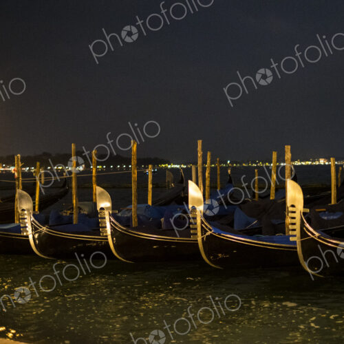 Illumintaed gondolas moored in the Canale Grande in Venice, Veneto, Italy, at night.