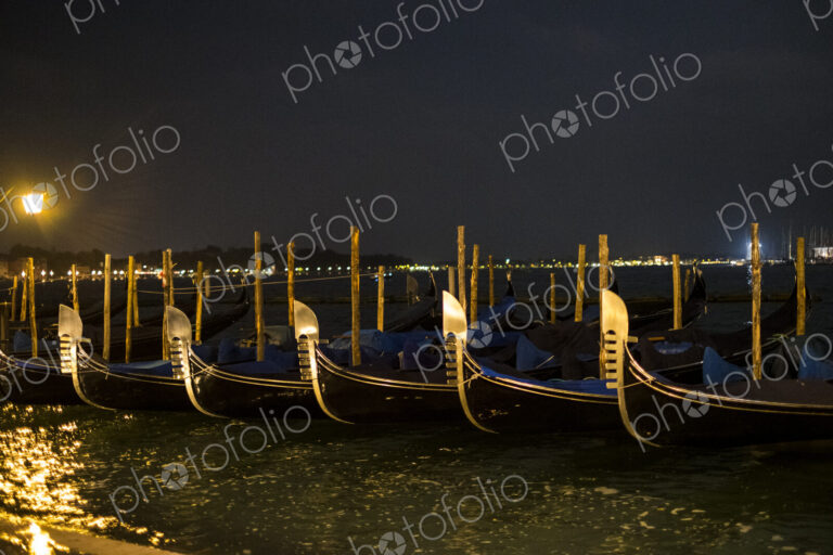 Illumintaed gondolas moored in the Canale Grande in Venice, Veneto, Italy, at night.