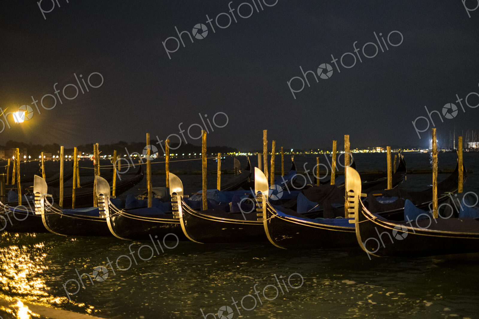 Illumintaed gondolas moored in the Canale Grande in Venice, Veneto, Italy, at night.