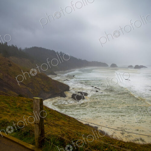 Indian Cove, Oregon Coast, the curving coastline and stormy seas breaking on shore.