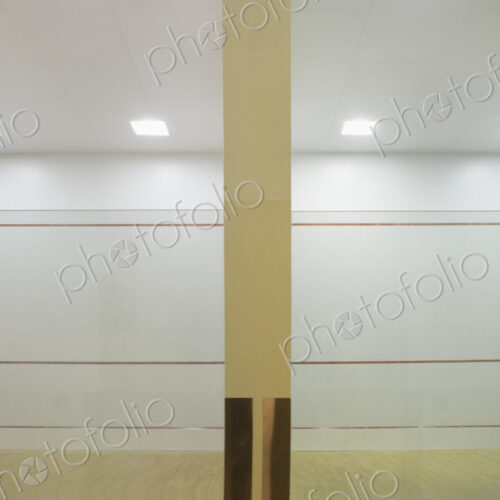 Indoor squash court with glass walls and markings.