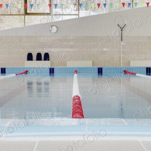 Indoor swimming pool, red and white dividers in swim lanes, surface view. Indoor swimming pool, red and white dividers in swim lanes, surface view.
