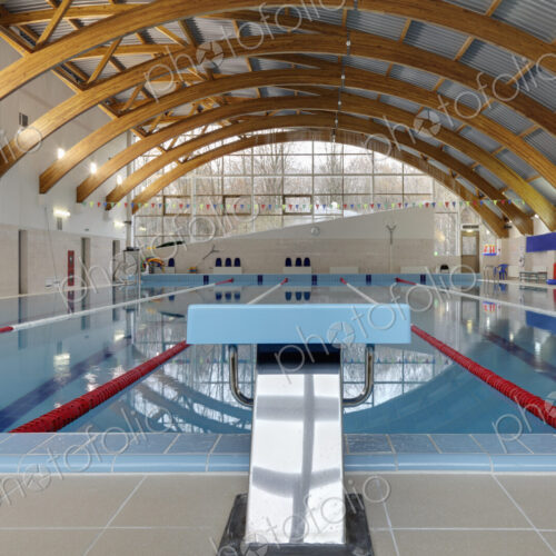 Indoor swimming pool, starting block, diving block and marked lanes, flat calm water Indoor swimming pool, starting block, diving block and marked lanes, flat calm water
