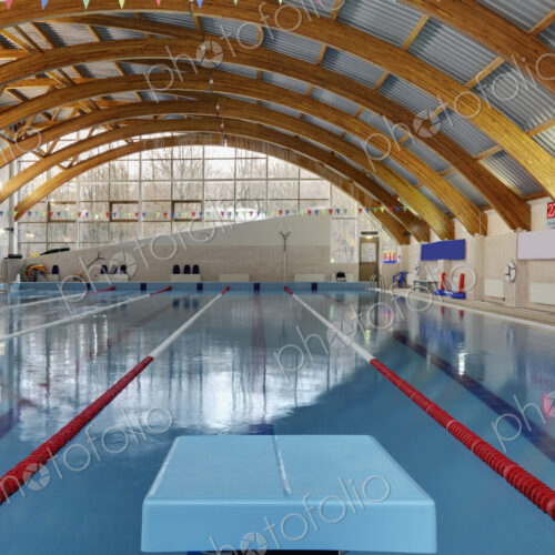 Indoor swimming pool with marked lanes, flat calm water and diving block Indoor swimming pool with marked lanes, flat calm water and diving block