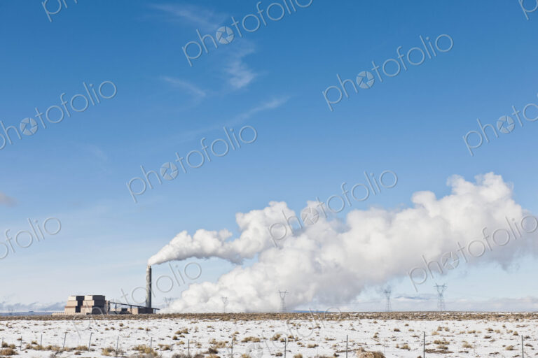 Industrial Complex and Snowy Landscape Under Blue Sky