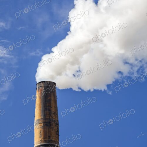 Industrial smokestack releasing white smoke against a clear blue sky in Port Angeles,… Industrial smokestack releasing white smoke against a clear blue sky in Port Angeles,…