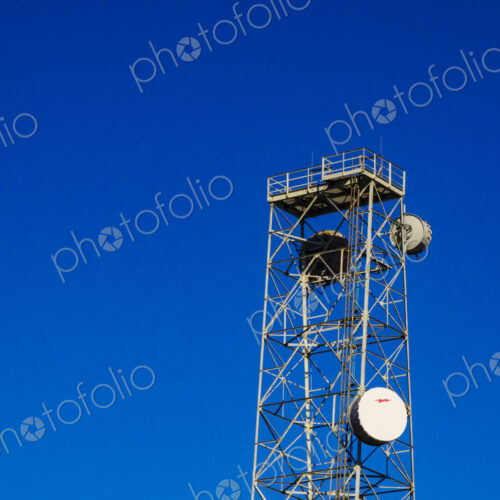 Infrastructure, a tall metal communication tower with a platform at the top, satelite…