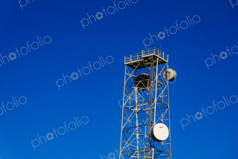 Infrastructure, a tall metal communication tower with a platform at the top, satelite…