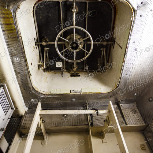 Interior door of a ferry, a ladder and a watertight door with a wheel locking mechanism.