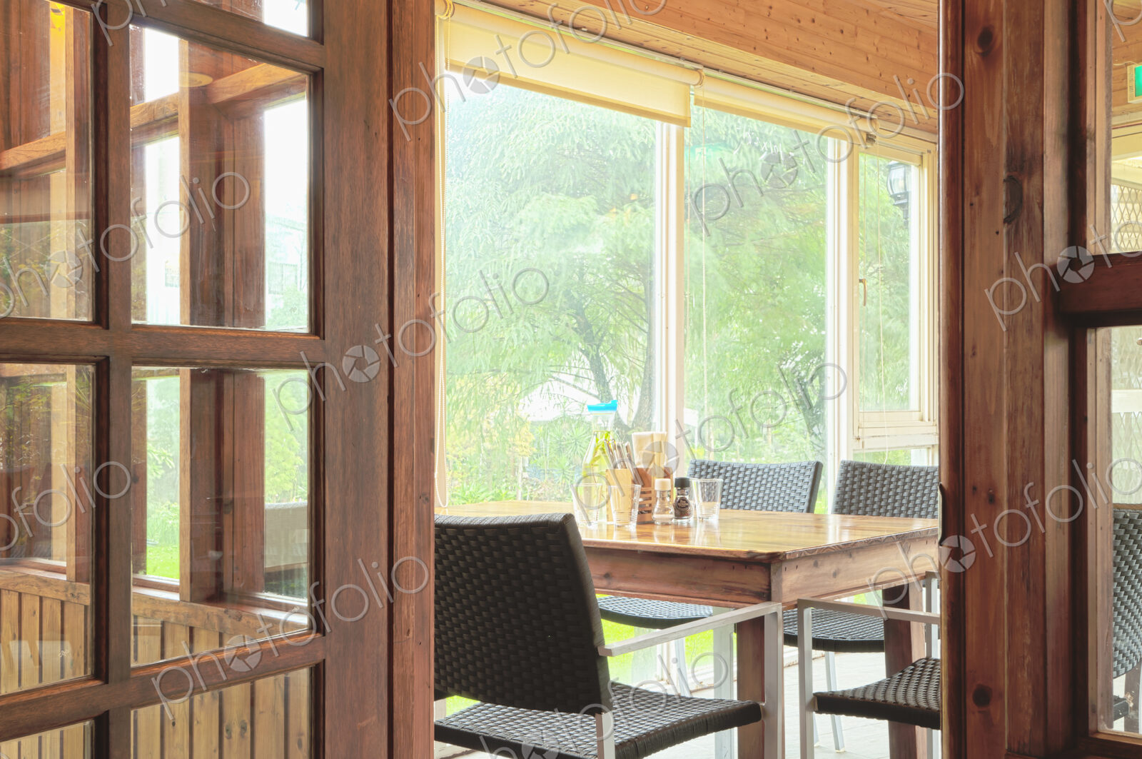 Interior of a dining room with windows onto woodland.