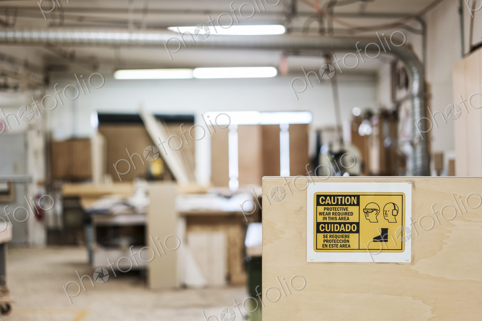 Interior of a woodworking factory showing a sign for safety gear regulations.