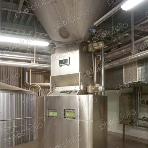 Interior of brewery, hopper and metal mashing tanks for brewing beer.