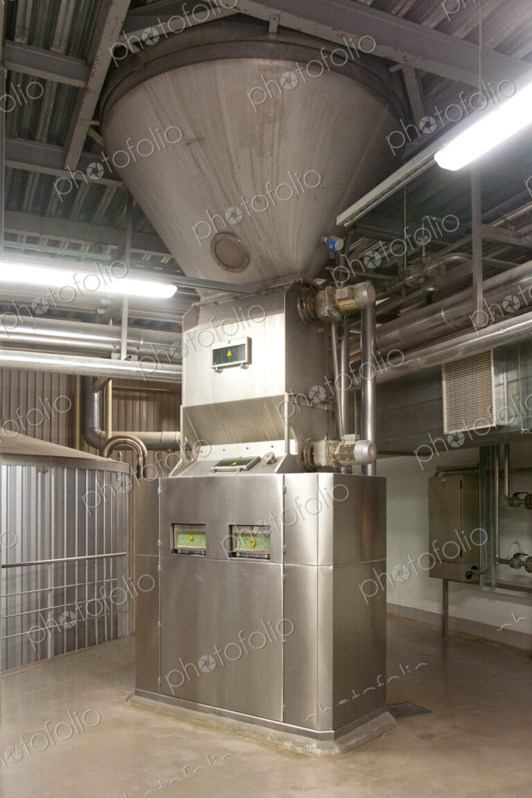 Interior of brewery, hopper and metal mashing tanks for brewing beer.