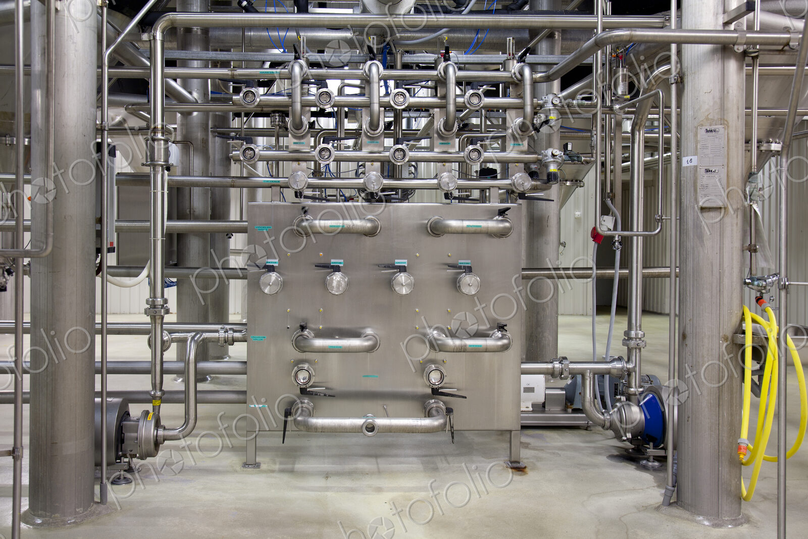 Interior of brewery, large steel pipes, valves and control unit for the brewing process