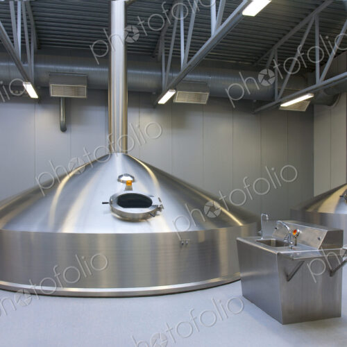 Interior of brewery, large steel storage tanks for brewing beer.