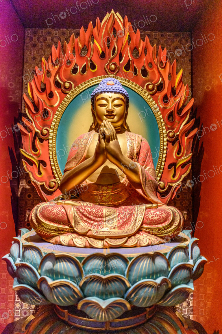 Interior view of a Buddhist Temple in Singapore, a seated buddha on a lotus flower.