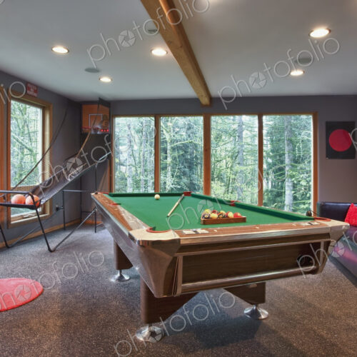 Interior view of a family games room with a pool table. Interior view of a family games room with a pool table.