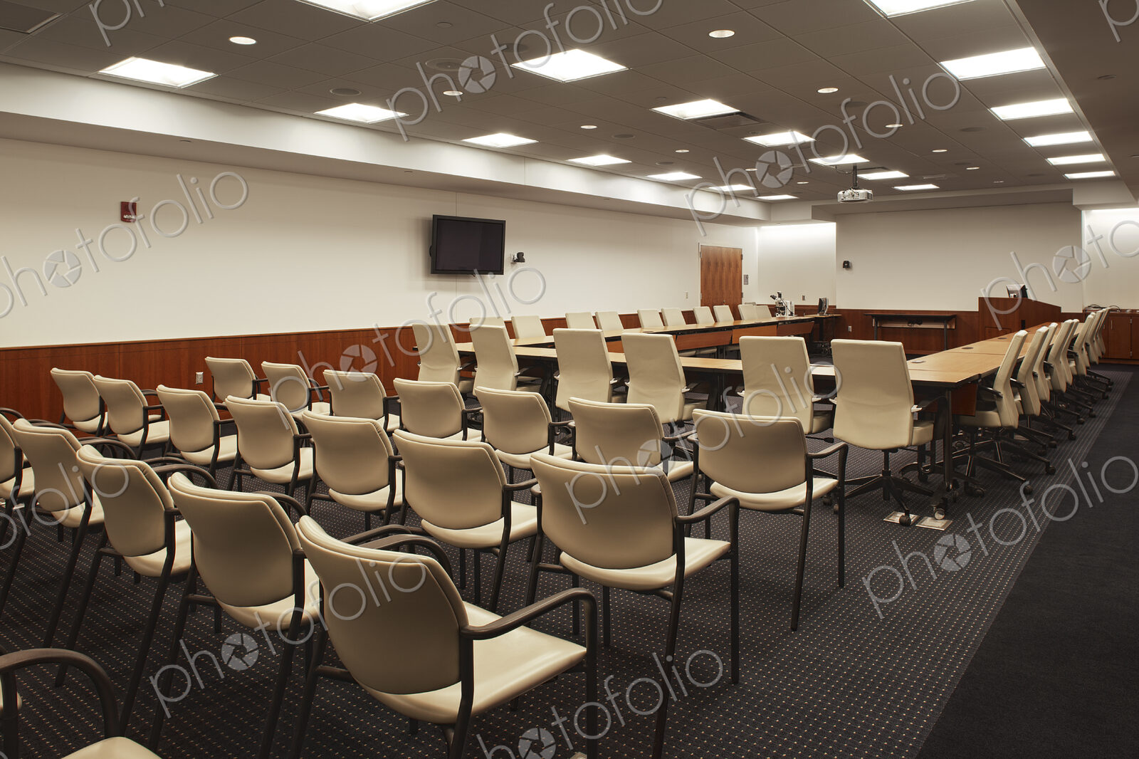 Interior view of a lecture hall or meeting room, a large conference table with a…