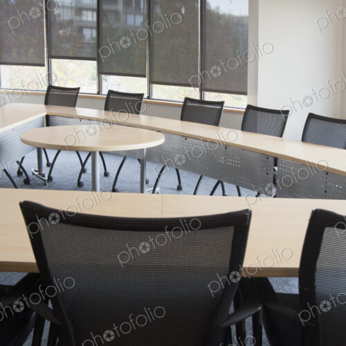 Interior view of a meeting room with a long narrow table set out with a space in the…
