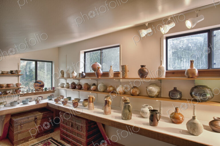 Interior view of a potter's workshop, rows of completed ceramic work, vases and pots…