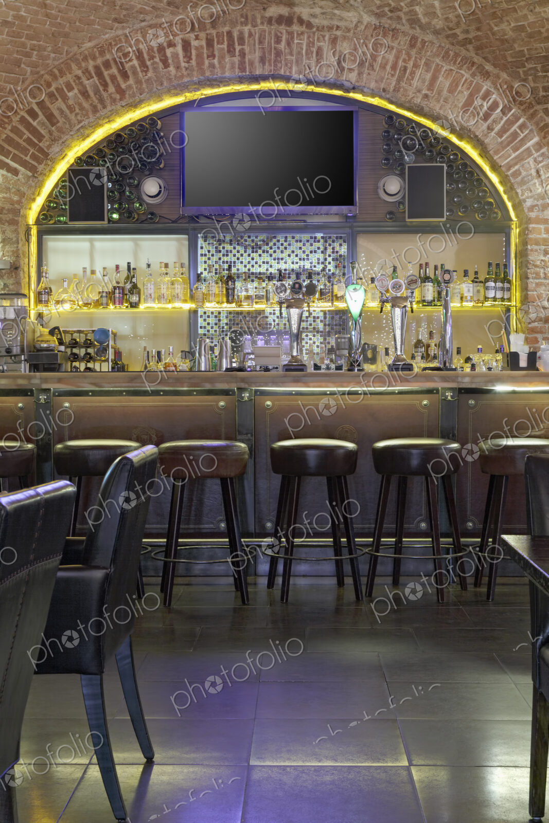 Interior view of bar with big TV screen on wall.